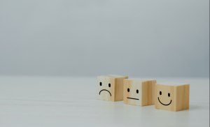 Three wooden cubes with emojis on them