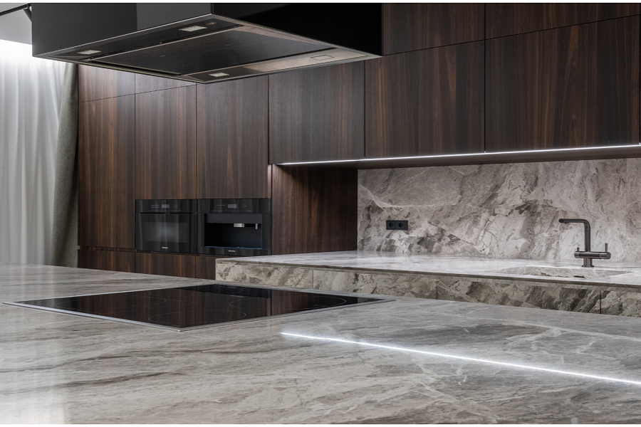 A kitchen with marble counter tops and a sink