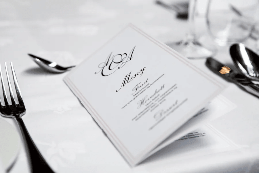 A table with silverware set for a meal, showcasing a menu